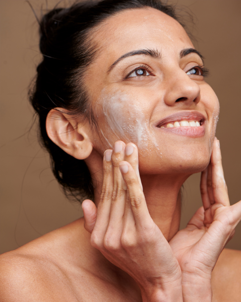 Woman applying a facial skincare product for clear, healthy skin