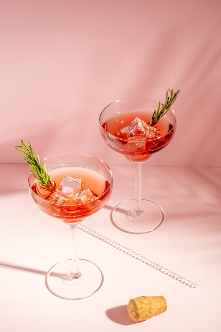 Pink cocktails with rosemary garnish — how alcohol affects hormonal acne and aging skin