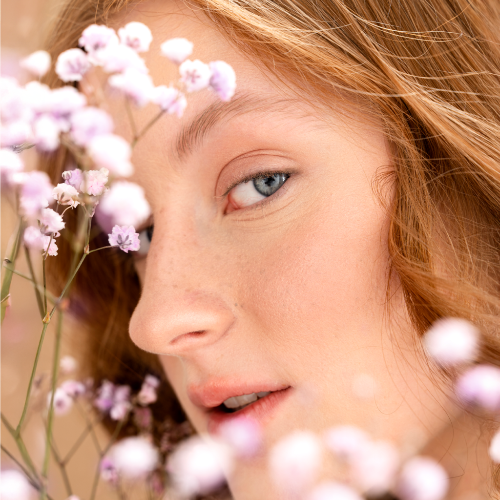 Close-up of fresh glowing skin with flowers, symbolizing a lightweight spring skincare routine for hormonal acne with SPF protection