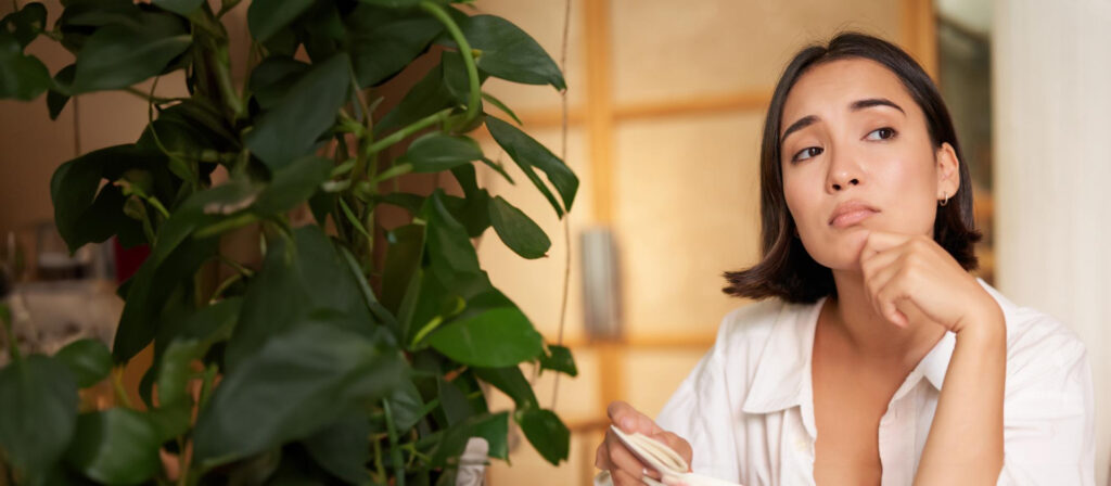 Young woman thinking and considering which retinoid to choose for her skincare routine