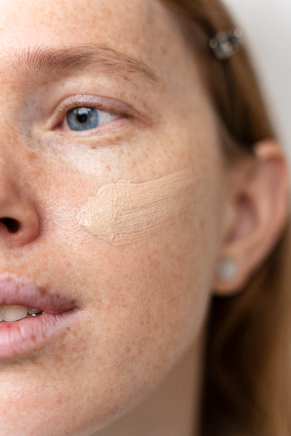 Woman applying tinted mineral sunscreen for hormonal acne