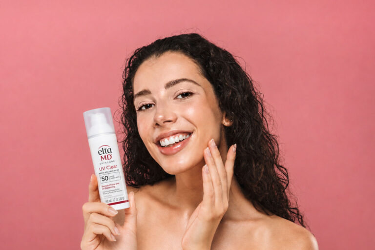 Woman holding EltaMD UV Clear sunscreen for hormonal acne