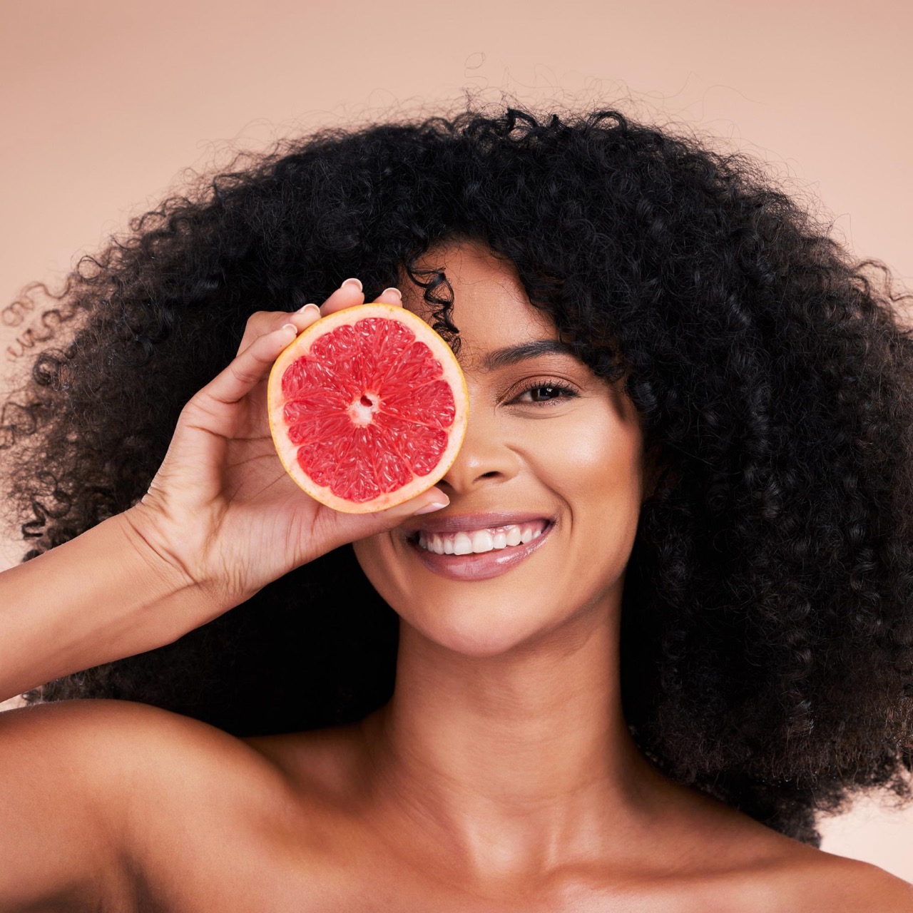 Woman holding a citrus fruit for collagen intake for healthy skin
