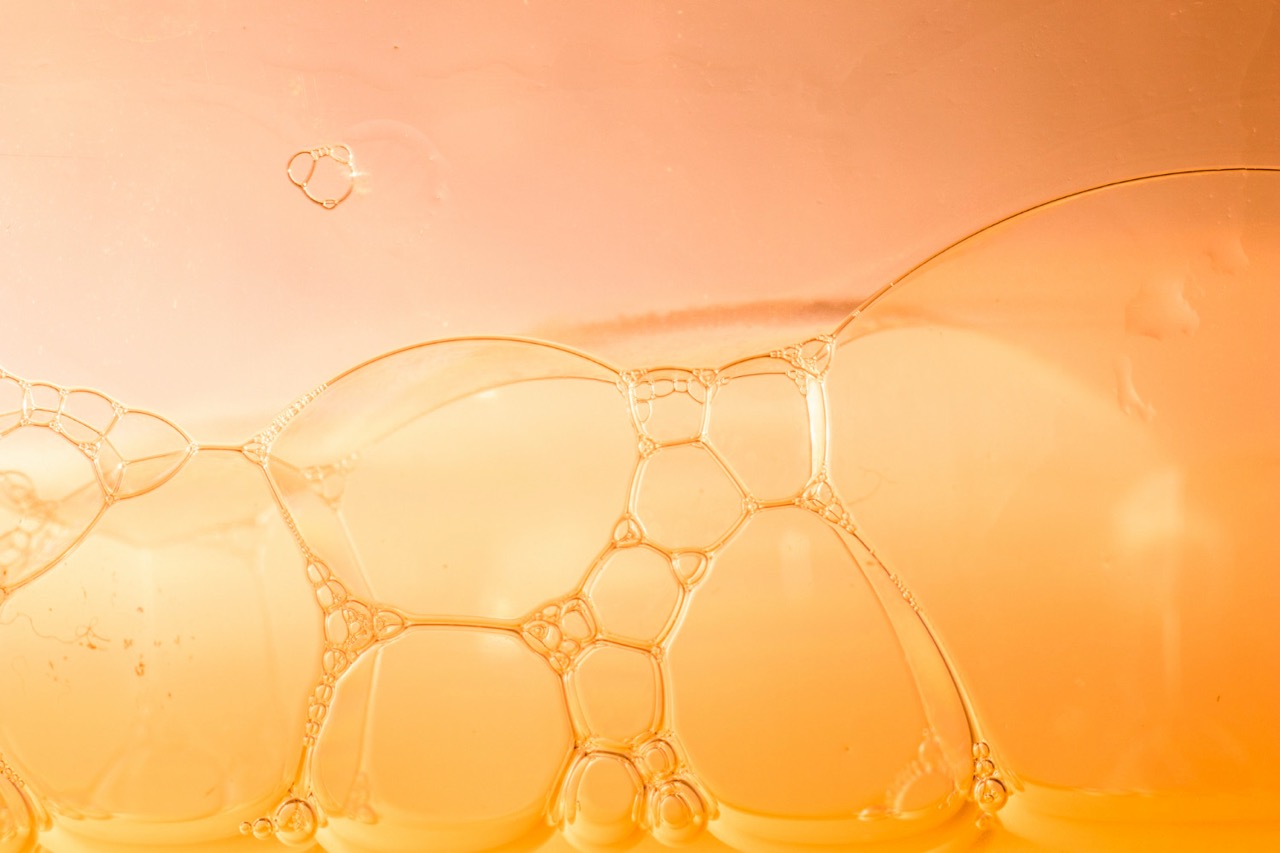 Golden vitamin C serum texture with bubbles representing brightening skincare