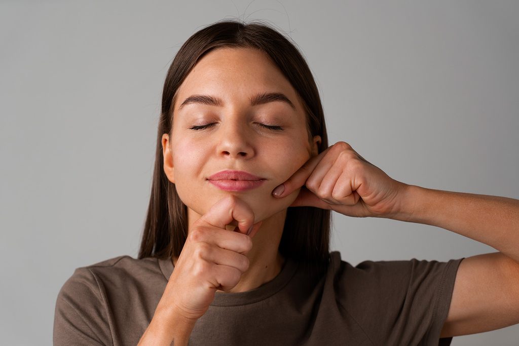 Woman doing a face yoga exercise along her jawline for firmness